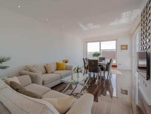 a living room with a couch and a table at On The Beach Penthouse with Sea View - 3 bedrooms - Roof Balcony - Spa, Sauna, Gym and Pool - Sleeps 6 in Brighton & Hove