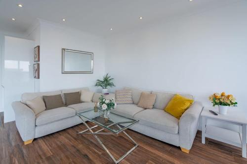 a living room with a couch and a table at On The Beach Penthouse with Sea View - 3 bedrooms - Roof Balcony - Spa, Sauna, Gym and Pool - Sleeps 6 in Brighton & Hove