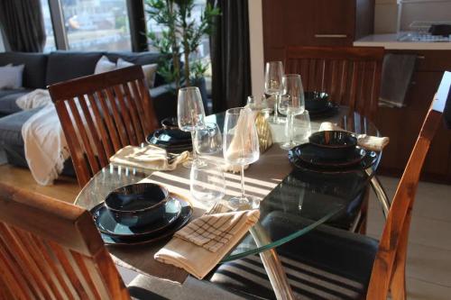 a dining table with glasses and plates on it at Custom House Square Penthouse in Belfast