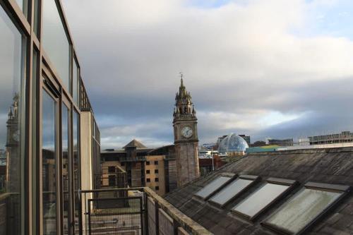 a clock tower on top of a building with a city at Custom House Square Penthouse in Belfast