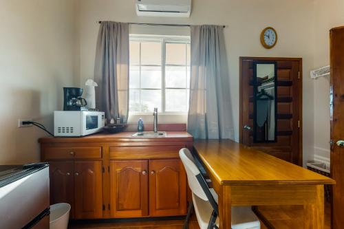 a kitchen with a wooden table and a microwave at Grampa Puli at Isebei Guest House -Gold Standard Certified in Hopkins
