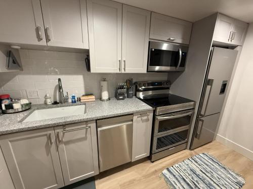 a kitchen with stainless steel appliances and white cabinets at Yosemite West Retreat B105 in Yosemite West