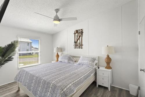 a white bedroom with a bed and a window at Pelican Point Paradise in Hackberry