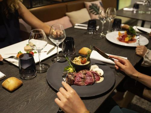 a group of people sitting at a table with a plate of food at Novotel Strasbourg Centre Halles in Strasbourg