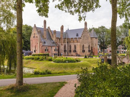 a large brick building with turrets at Wellness woning met sauna in Andijk