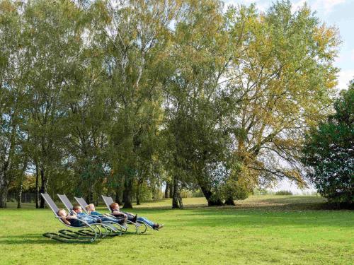 a group of people sitting in lawn chairs in a park at Novotel Roissy Saint Witz in Saint-Witz