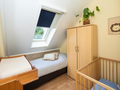 a small bedroom with a bed and a window at Villa in Andijk with Hot Tub and Garden in Andijk