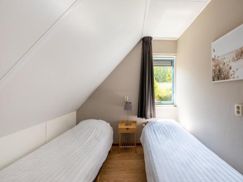 two beds in a room with a window at Villa in Medemblik near Waterfront in Andijk