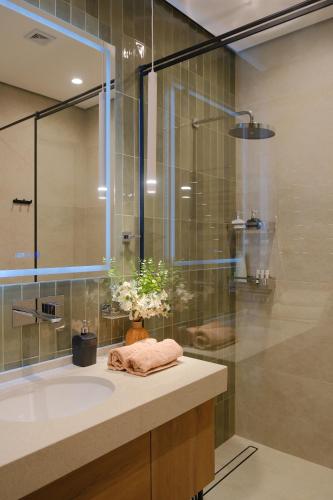a bathroom with a sink and a glass shower at Nest One Luxe, Элитные апартаменты с балконом и видом на фонтан Tashkent City Park 008 in Tashkent
