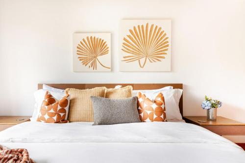 a bedroom with a bed with pillows and art on the wall at Casa Cielo 3 BR Penthouse with Views in La Romana
