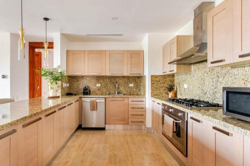 a kitchen with wooden cabinets and a white refrigerator at Casa Cielo 3 BR Penthouse with Views in La Romana