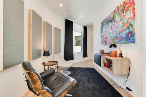 a living room with a leather chair and a table at Unique Round House, Near State Fair, Modern Luxury in Dallas