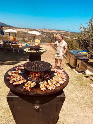 a man standing next to a barbecue grill at Villa Alexander,Suite Imperiale con idromassaggio in Trarivi