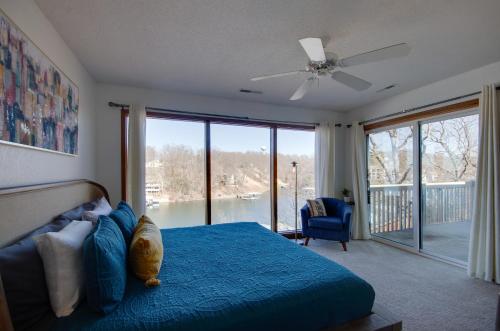 オーセージ・ビーチにあるPool and Lake Access Waterfront Osage Beach Retreatのベッドルーム(青いベッド1台、大きな窓付)