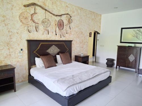 a bedroom with a large bed and a wall with clocks at Villas Montserrat Wellness Center in Guadalupe
