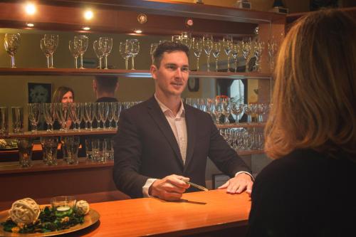 a man sitting at a bar talking to a woman at Hotel Wolf in Prague