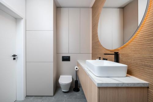 ウッチにあるŚwiętojańska Harmony Apartment by BookingHostの洗面台と鏡のあるバスルーム