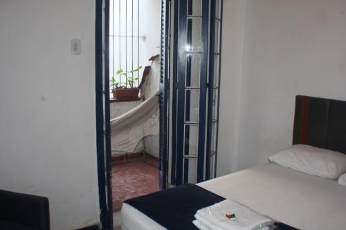 a bedroom with a bed and a window with a balcony at Farfalla Guest House in Rio de Janeiro