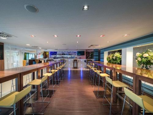 a bar in a restaurant with tables and chairs at Ibis Styles Linz in Linz