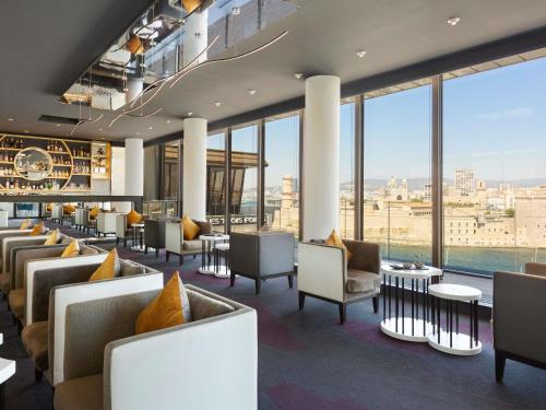 a hotel lobby with couches and tables and large windows at Sofitel Marseille Vieux-Port in Marseille