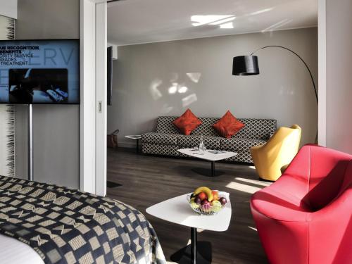 a room with a bed and a couch and a table at Pullman Dakar Teranga in Dakar