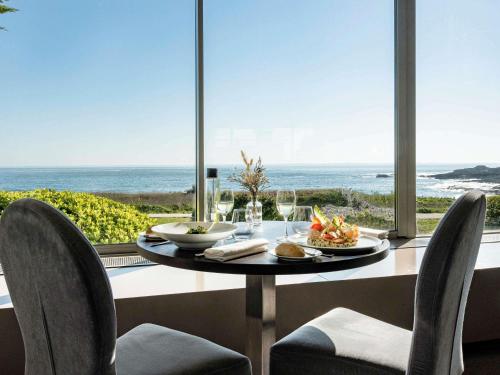 a dining table with a view of the ocean at Sofitel Quiberon Thalassa sea & spa in Quiberon