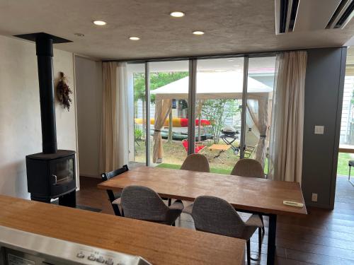 een eetkamer met een tafel en een houtkachel bij Urara Holiday in Sumoto
