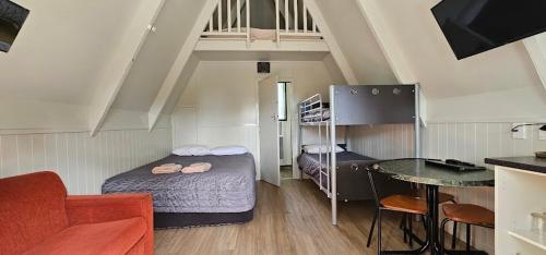 a small room with a bed and a table at Westport Kiwi Holiday Park & Motels in Westport