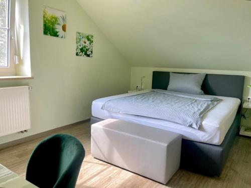 a bedroom with a bed and a chair in it at Das SinGold Hotel mit Highspeed WLAN und digitalem Schlüssel in Schwabmünchen