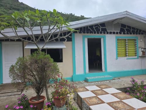 a house with a tree and flowers in front of it at Bonheur a Maupiti in Maupiti