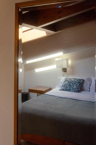 a bedroom with a bed with a wooden frame at Casa Albañil in La Puebla de Castro