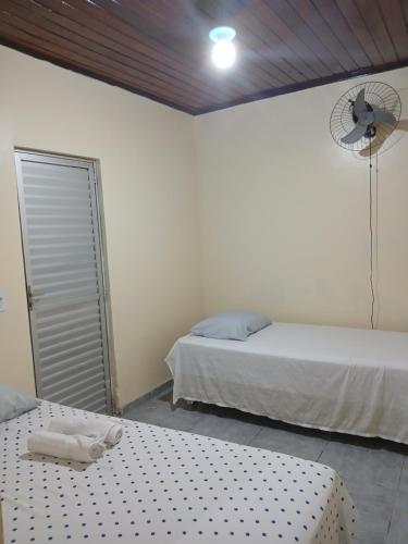Chapéu ViradoにあるApartamento no Murubiraのベッドルーム1室(ベッド2台、壁にファン付)