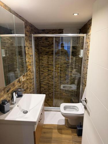 a bathroom with a shower and a sink and a toilet at Deluxe Beach Residence in Samsun