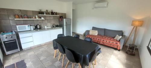 eine Küche und ein Wohnzimmer mit einem Tisch und einem Sofa in der Unterkunft Casa de Campo Vuelta de Obligado in Vuelta de Obligado