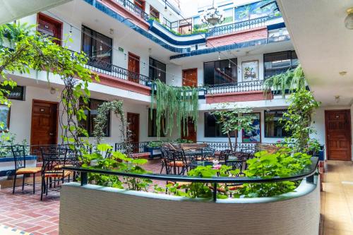 a courtyard with tables and chairs and plants at Hotel El Indio Inn in Otavalo