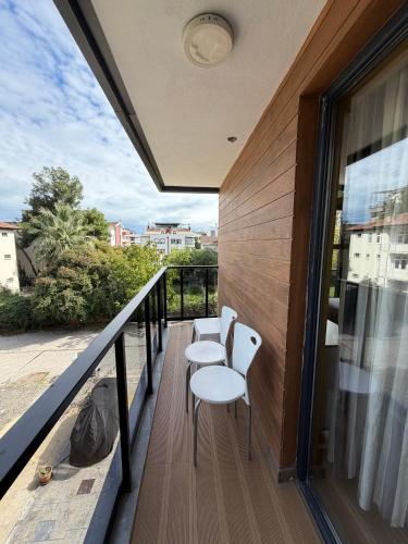 a balcony with two white chairs and a railing at Deluxe Beach Residence in Samsun