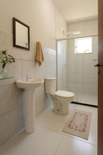 a white bathroom with a toilet and a sink at Casa Toniatti 2 in Barra Grande