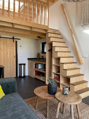 a living room with a staircase and a table at Marina Strandbad TinyHouse Pawradise in Olburgen