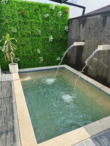a swimming pool with a water fountain at Casa Mujer Ceiba - Indoor Pool - We Invoice in Tierra Colorada