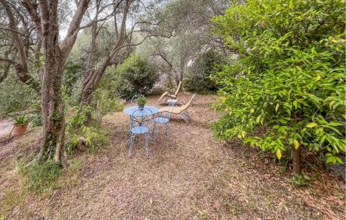 a table and chairs sitting in a forest at 1 Bedroom Stunning Home In Peymeinade in Spéracèdes