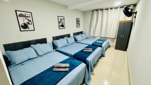a room with two beds with blue sheets at Casa Família no Parque Edu Chaves in Sao Paulo