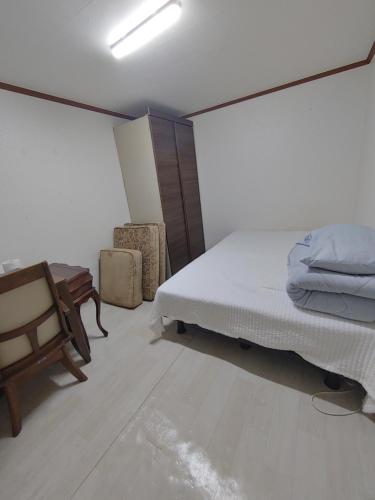 a bedroom with a bed and a desk and a chair at Sinchon House close to the airport in Seoul