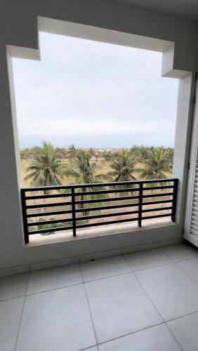 a room with a large window with a view of palm trees at Moroj Al Zain - M82 in Salalah
