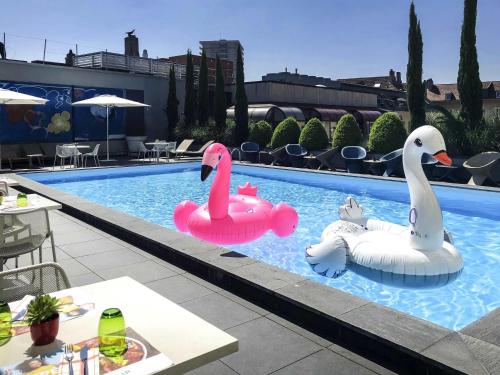 two inflatable swans in a swimming pool at Novotel Metz Centre in Metz