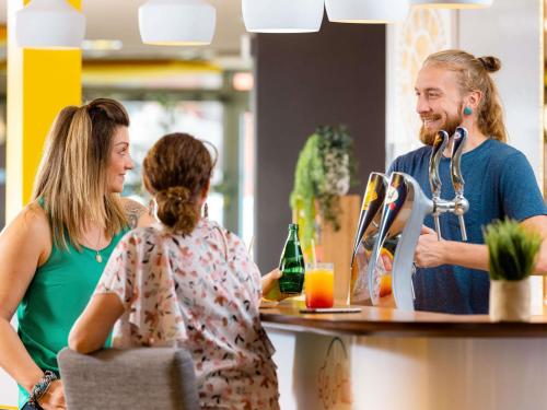 a man and a woman standing at a counter at ibis Montélimar Nord in Saulce-sur-Rhône