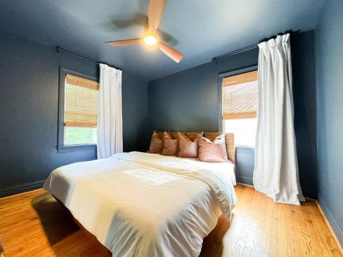 a blue bedroom with a bed with a ceiling fan at Better than a Hotel - King / Bunkbed / Laundry in Gallatin