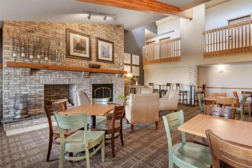a restaurant with tables and chairs and a fireplace at SureStay Plus Hotel by Best Western Litchfield in Litchfield
