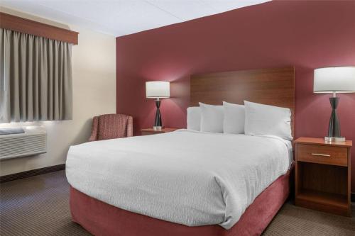 a hotel room with a large bed and two lamps at SureStay Plus Hotel by Best Western Litchfield in Litchfield