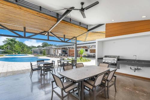 an open kitchen and dining room with a table and chairs at Upstay - New Condo Just Steps Away from the Beach in Jacó