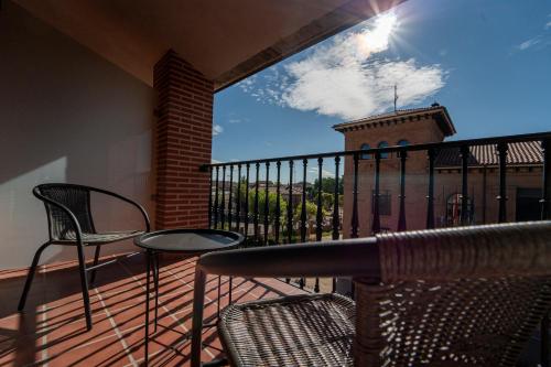 a balcony with chairs and a table and a building at Olmedo Hostal Plaza in Olmedo